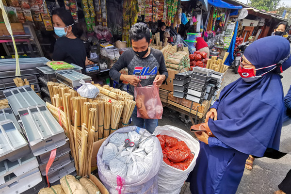 Pedagang melayani pembeli di Pasar Palmerah, Jakarta Barat, Selasa (20/7/2021).
