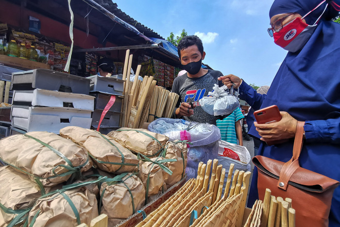 Pedagang melayani pembeli di Pasar Palmerah, Jakarta Barat, Selasa (20/7/2021).