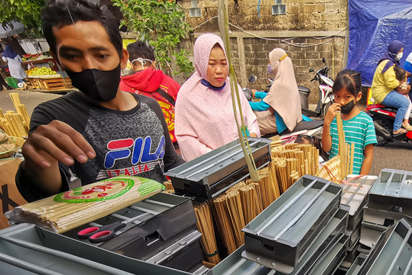 Pedagang melayani pembeli di Pasar Palmerah, Jakarta Barat, Selasa (20/7/2021).