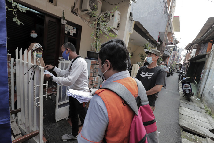 Juru Bayar Kantor Pos Indonesia memotret warga penerima Bantuan Sosial Tunai (BST) di wilayah Kelurahan Petojo Selatan, Jakarta, Rabu (21/7/2021).