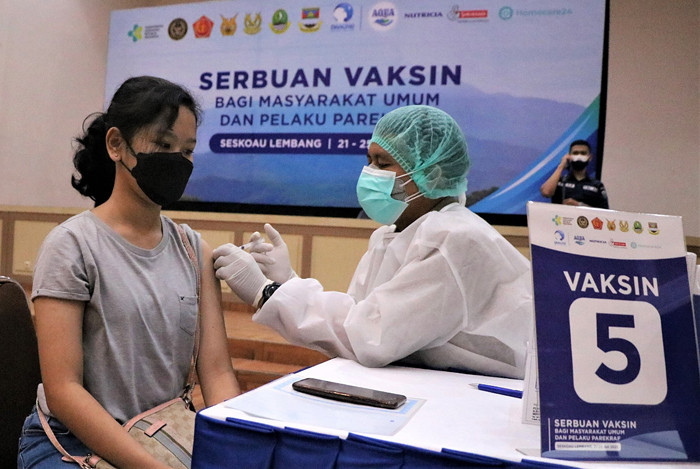 Petugas menyuntikan vaksin kepada Warga saat Serbuan Vaksinasi di GOR Widya Dirgantara, Seskoau, Lembang, Bandung, Rabu (21/7/2021).