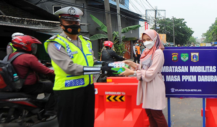 Pegawai PT Bank Tabungan Negara (Persero) Tbk membagikan makanan dan hand sanitizer kepada petugas di kawasan Samsat Daan Mogot, Jakarta, Kamis (22/7/2021).