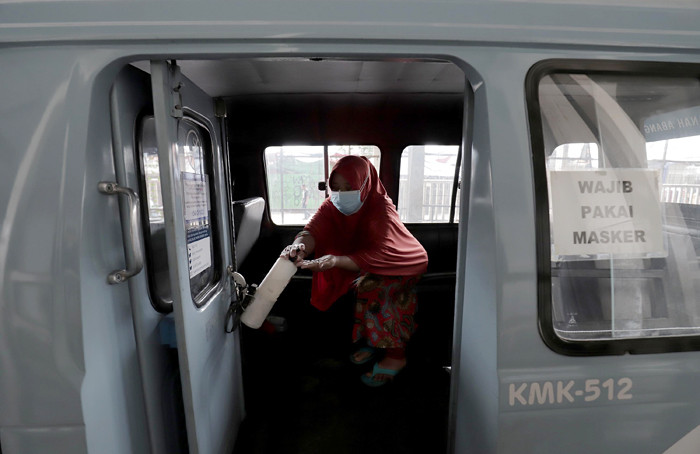 Supir angkutan Jak Lingko mengenakan masker saat menunggu penumpang di Tanah Abang, Jakarta, Kamis (22/7/2021).