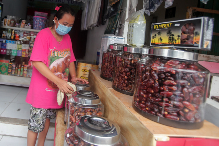 Penjual menata dagangannya di salah satu kios oleh-oleh Haji dan Umroh di kawasan Asrama Haji Pondok Gede, Jakarta Timur, Kamis (22/7/2021).