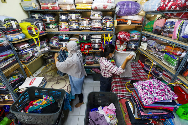 Pekerja sedang menyelesaikan pakaian yang akan dicuci di salah satu usaha jasa pencucian pakaian atau laundry di Jakarta Barat, Jumat (23/7/2021).