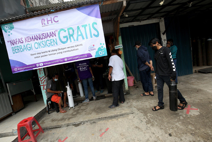 Sejumlah warga antre untuk mendapatkan isi ulang oksigen medis yang dibagikan secara gratis di Jalan Minangkabau Timur, Jakarta, Jumat (23/7/2021).