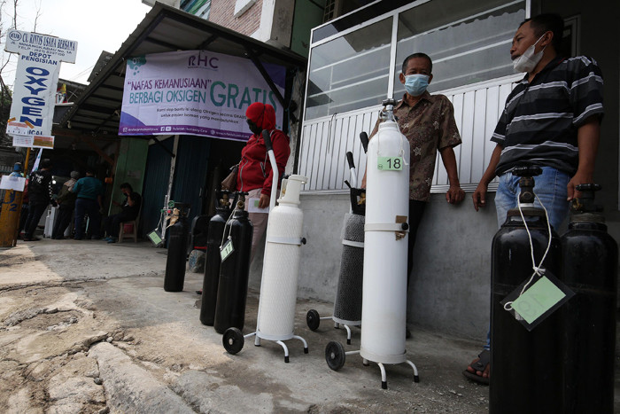 Sejumlah warga antre untuk mendapatkan isi ulang oksigen medis yang dibagikan secara gratis di Jalan Minangkabau Timur, Jakarta, Jumat (23/7/2021).