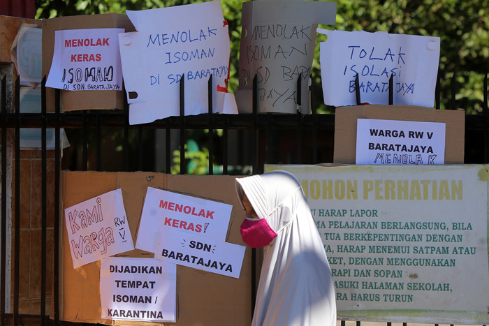 Puluhan warga berorasi dan membentangkan poster ketika aksi didepan SDN Baratajaya Surabaya, Jawa Timur, Jumat (23/7/2021).