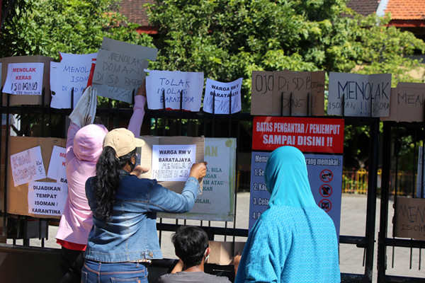 Puluhan warga berorasi dan membentangkan poster ketika aksi didepan SDN Baratajaya Surabaya, Jawa Timur, Jumat (23/7/2021).