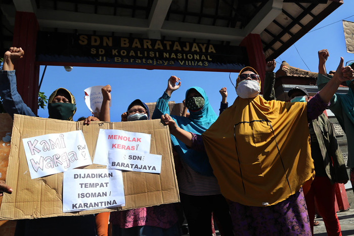 Puluhan warga berorasi dan membentangkan poster ketika aksi didepan SDN Baratajaya Surabaya, Jawa Timur, Jumat (23/7/2021).