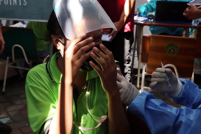 Seorang buruh meronta karena takut jarum suntik saat mengikuti vaksinasi bagi pekerja di PT Integra Indocabinet, Sidoarjo, Jawa Timur, Sabtu (24/7/2021).