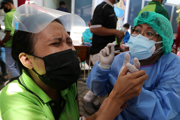 Seorang buruh meronta karena takut jarum suntik saat mengikuti vaksinasi bagi pekerja di PT Integra Indocabinet, Sidoarjo, Jawa Timur, Sabtu (24/7/2021).