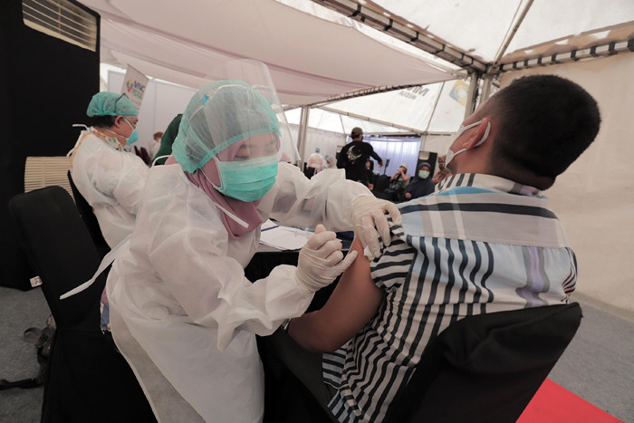 Petugas kesehatan menyuntikkan vaksin Covid-19 kepada warga di sentra vaksinasi MNC Center, Kebon Jeruk, Jakarta Barat, Sabtu (24/7/2021).