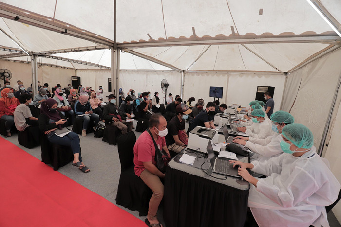 Petugas kesehatan menyuntikkan vaksin Covid-19 kepada warga di sentra vaksinasi MNC Center, Kebon Jeruk, Jakarta Barat, Sabtu (24/7/2021).