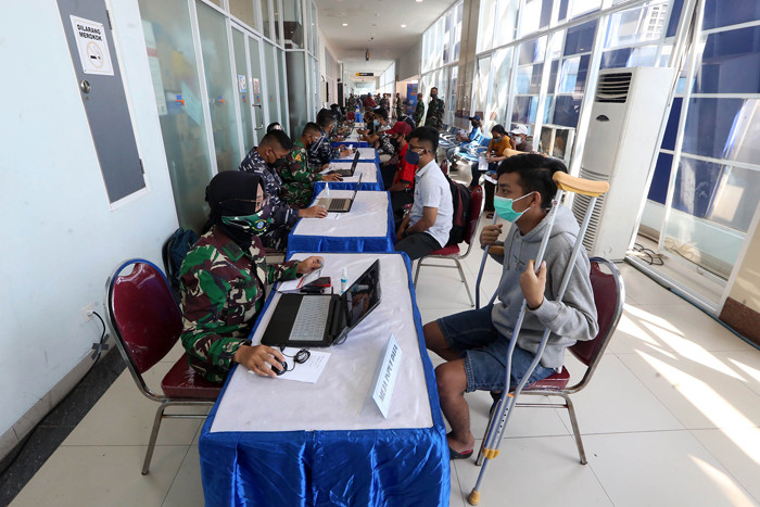 Peserta vaksin menutup muka ketika mendapat suntikan vaksin Covid-19 dalam serbuan vaksin masyarakat maritim di Gedung GSN, Jawa Timur, Senin (26/7/2021).