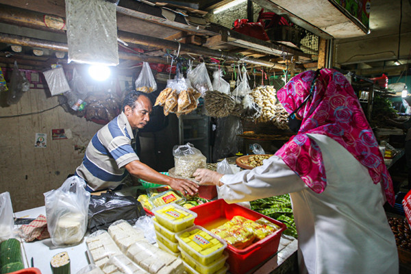 Pedagang merapikan dagangannya di Pasar Pondok Gede, Kota Bekasi, Jawa Barat, Senin (26/7/2021).