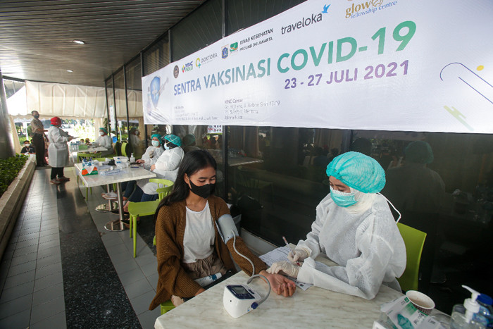 Warga mengikuti vaksinasi Covid-19 di Sentra Vaksinasi MNC Center, Kebon Sirih, Jakarta Pusat, Senin (26/7/2021).