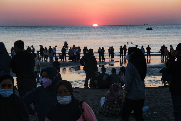 Suasana pengunjung menikmati matahari terbenam di Pantai Indah Bosowa, Makassar, Minggu (25/7/2021).
