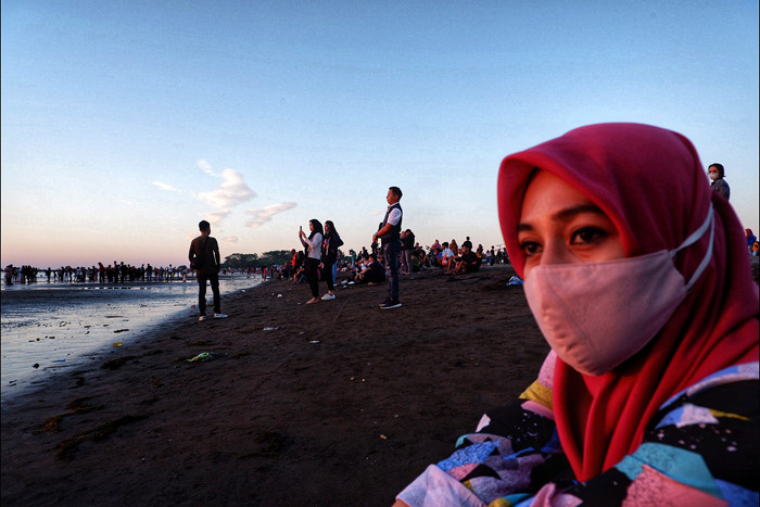 Suasana pengunjung menikmati matahari terbenam di Pantai Indah Bosowa, Makassar, Minggu (25/7/2021).