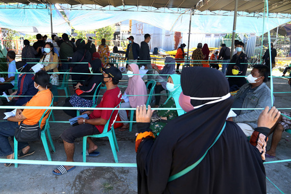 Suasana antrean pengambilan Bantuan Sosial Tunai (BST) di Lapangan Pacar Keling, Surabaya, Jawa Timur, Selasa (27/7/2021).