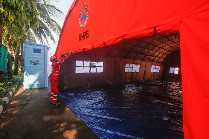 Petugas Palang Merah Indonesia (PMI) memeriksa kesiapan selter atau tenda darurat untuk pasien isolasi mandiri Covid-19 di Jakarta, Selasa (27/7/2021).