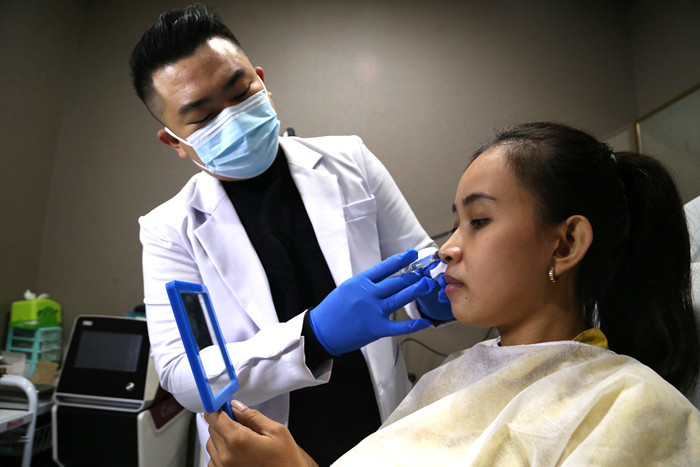 Dokter Michael Lawanto melakukan perawatan kulit wajah pasien di Beauty Skin dr MF Surabaya, Jawa Timur, Rabu (28/7/2021).