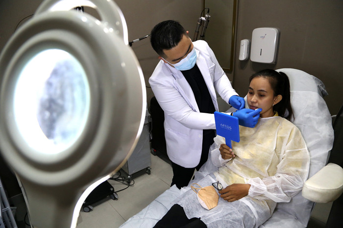 Dokter Michael Lawanto melakukan perawatan kulit wajah pasien di Beauty Skin dr MF Surabaya, Jawa Timur, Rabu (28/7/2021).