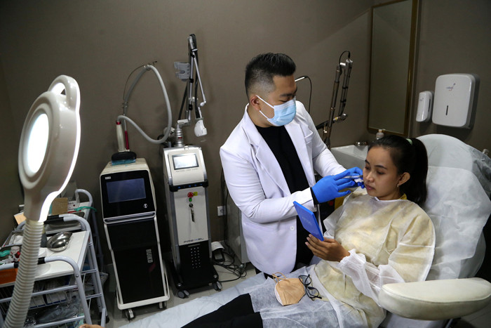 Dokter Michael Lawanto melakukan perawatan kulit wajah pasien di Beauty Skin dr MF Surabaya, Jawa Timur, Rabu (28/7/2021).