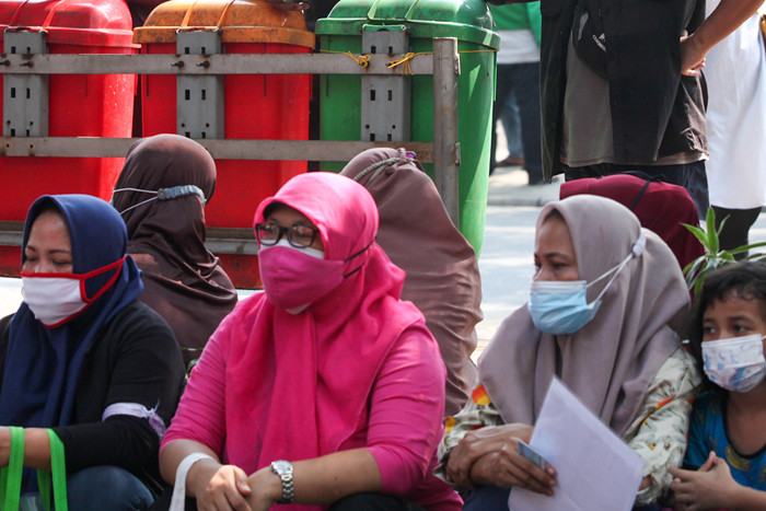 Warga saat menerima bantuan sosial (bansos) tunai di kawasan Kedoya Selatan, Jakarta Barat, Rabu (28/7/2021).