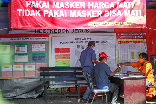 Warga saat menerima bantuan sosial (bansos) tunai di kawasan Kedoya Selatan, Jakarta Barat, Rabu (28/7/2021).