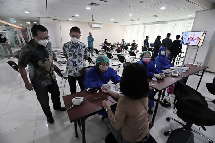 Petugas medis menyuntikan vaksin Covid-19 kepada warga di Jakarta, Rabu (28/7/2021).