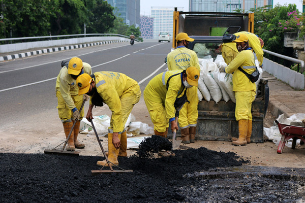 Pekerja Suku Dinas Bina Marga Jakarta Pusat mengaspal jembatan flyover HOS Cokroaminoto yang ambles di Jakarta, Kamis (29/7/2021).