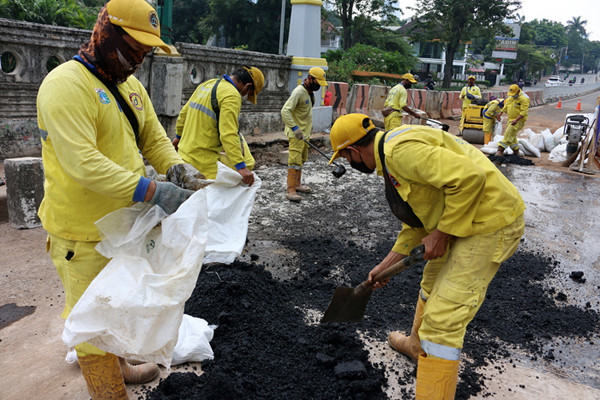 Pekerja Suku Dinas Bina Marga Jakarta Pusat mengaspal jembatan flyover HOS Cokroaminoto yang ambles di Jakarta, Kamis (29/7/2021).
