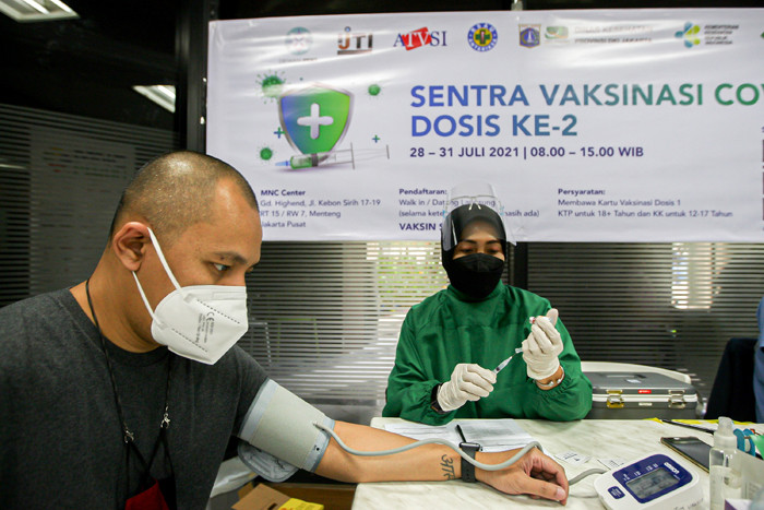 Petugas medis menyuntikan vaksin covid-19 jenis Sinovac kepada warga di Gedung Highend, MNC Center, Jakarta, Jumat (30/7/2021).