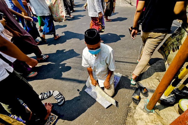Jamaah saat menjalankan shalat jumat dengan protokol kesehatan di luar lingkungan masjid dikarenakan pembatasan kapasitas di Jakarta Barat, Jumat (30/7/2021).
