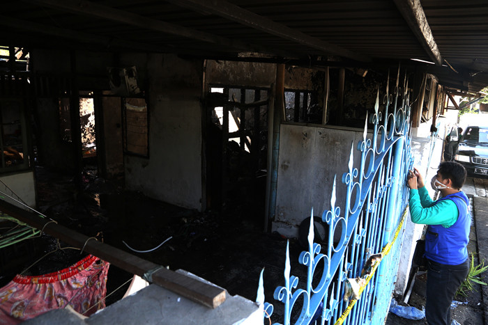 Petugas K3 ITS Surabaya memeriksa kondisi salah satu rumah usai terbakar di Jalan Teknik Komputer, Perumahan Dosen ITS Surabaya, Jawa Timur, Jumat (30/7/2021).