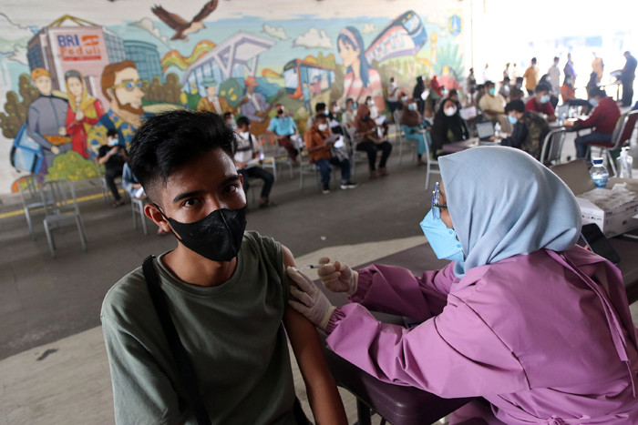 Tenaga kesehatan menyuntikkan vaksin Covid-19 kepada warga di Terowongan Kendal, Jakarta, Jumat (30/7/2021).