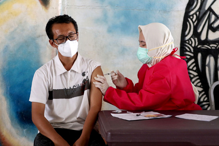 Tenaga kesehatan menyuntikkan vaksin Covid-19 kepada warga di Terowongan Kendal, Jakarta, Jumat (30/7/2021).