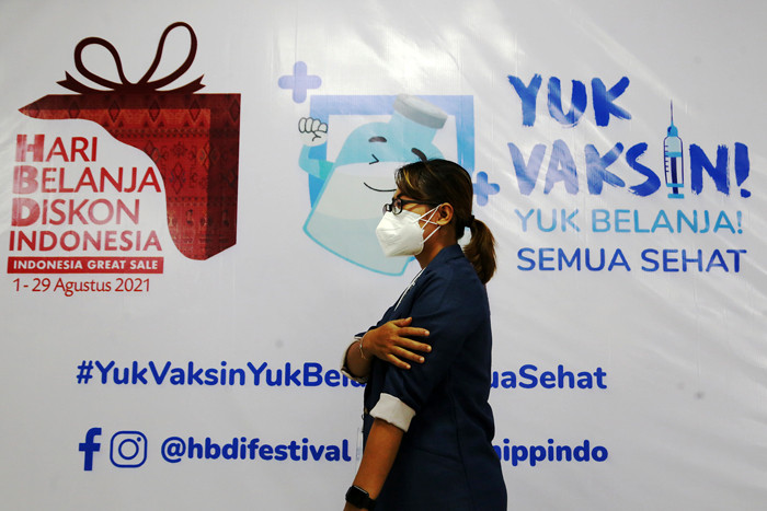 Para pelaku UMKM, pedagang dan masyarakat mengantri untuk mendapatkan vaksin Covid-19 dosis pertama di Sentra Vaksinasi Uniqlo di Surabaya, Jumat (30/7/2021).