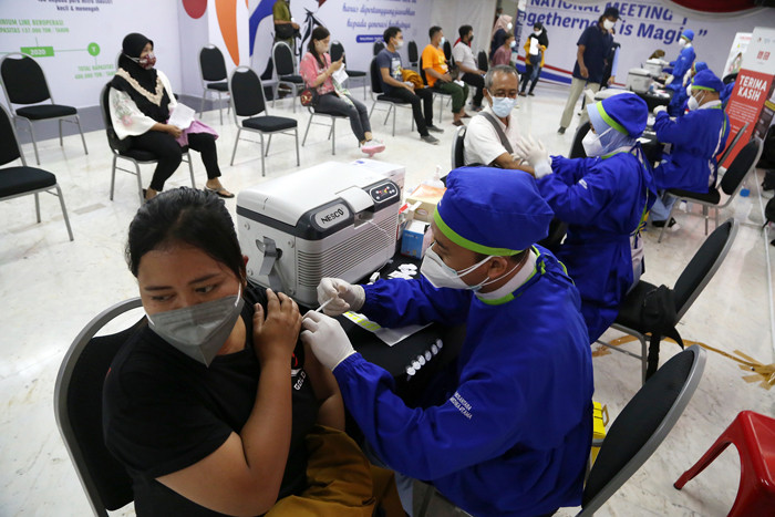 Para pelaku UMKM, pedagang dan masyarakat mengantri untuk mendapatkan vaksin Covid-19 dosis pertama di Sentra Vaksinasi Uniqlo di Surabaya, Jumat (30/7/2021).