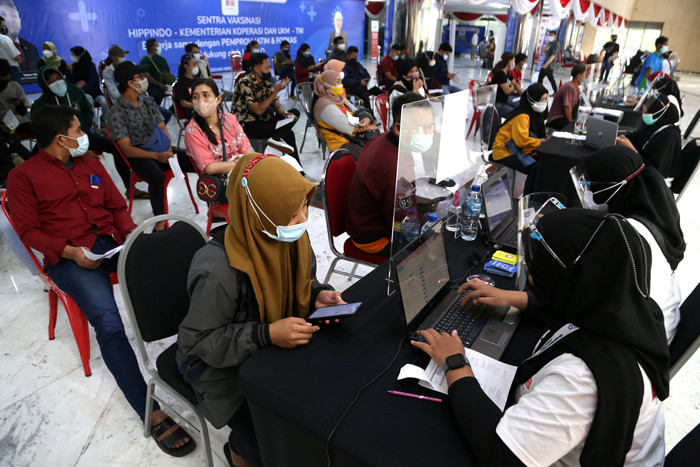 Para pelaku UMKM, pedagang dan masyarakat mengantri untuk mendapatkan vaksin Covid-19 dosis pertama di Sentra Vaksinasi Uniqlo di Surabaya, Jumat (30/7/2021).
