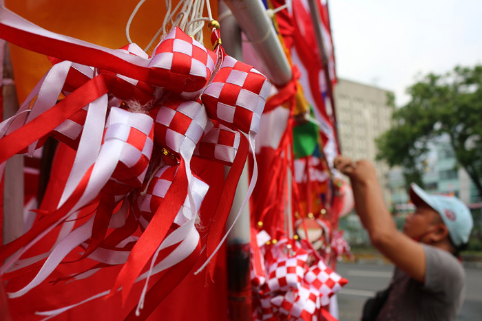 Penjual bendera merah putih dan pernak-pernik HUT Kemerdekaan Republik Indonesia yang Ke-76 merapikan dagangannya di Jalan Matraman, Jakarta (31/7/2021).