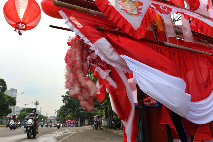 Penjual bendera merah putih dan pernak-pernik HUT Kemerdekaan Republik Indonesia yang Ke-76 merapikan dagangannya di Jalan Matraman, Jakarta (31/7/2021).