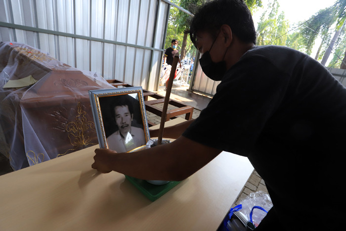 Petugas krematorium bersama keluarga duka mengangkat peti jenazah Covid-19 untuk dikremasi di TPU Tegal Alur, Jakarta, Sabtu (31/7/2021).