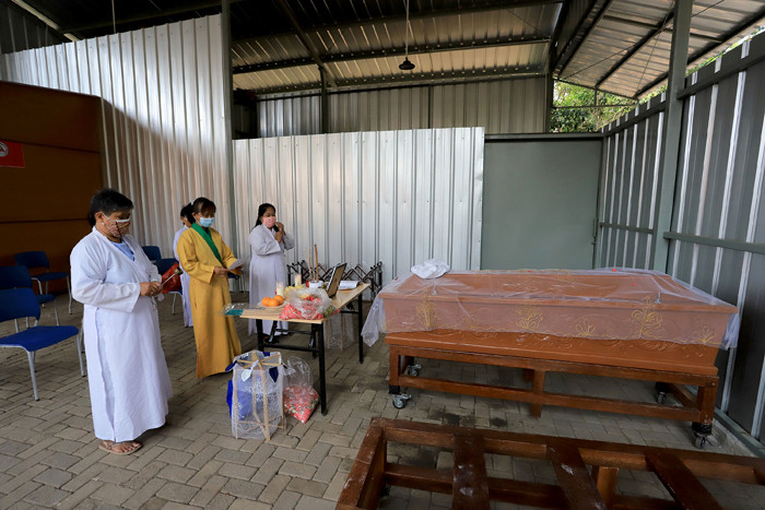Petugas krematorium bersama keluarga duka mengangkat peti jenazah Covid-19 untuk dikremasi di TPU Tegal Alur, Jakarta, Sabtu (31/7/2021).