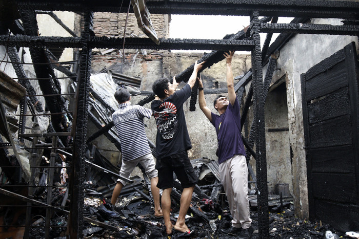 Petugas pemadam kebakaran melakukan pendinginan terhadap bangunan yang terbakar di Jalan Karet Pasar Baru, Karet Tengsin, Jakarta Pusat, Sabtu (31/7/2021).