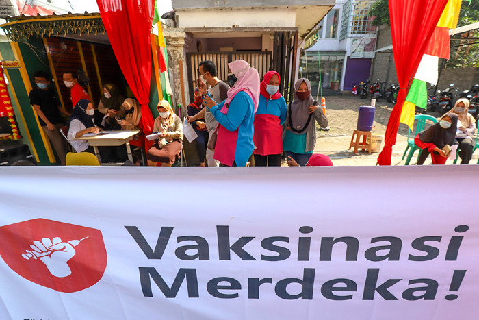 Warga saat mengikuti vaksin merdeka yang dimulai hari ini dengan nuansa seperti hajatan di Jakarta Barat, Minggu (1/8/2021).