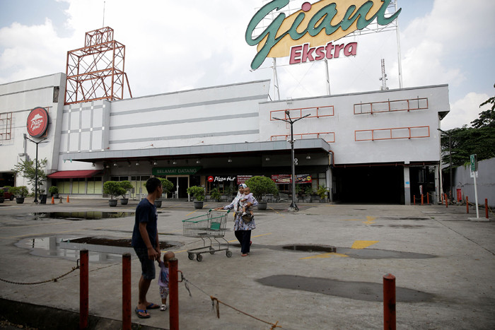 Pengunjung mendorong keranjang belanjaan di depan Supermarket Giant Ekstra di Kreo, Tangerang, Senin (2/8/2021).