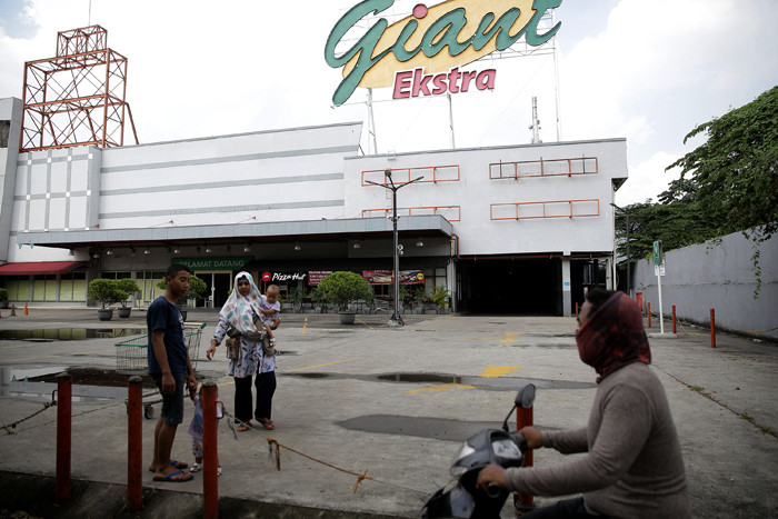 Pengunjung mendorong keranjang belanjaan di depan Supermarket Giant Ekstra di Kreo, Tangerang, Senin (2/8/2021).