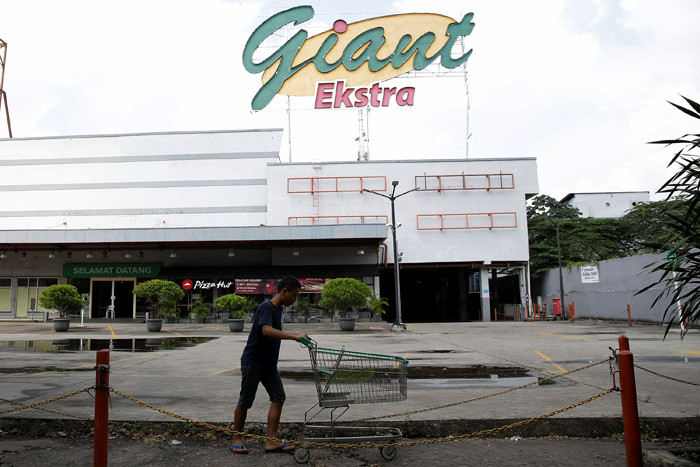 Pengunjung mendorong keranjang belanjaan di depan Supermarket Giant Ekstra di Kreo, Tangerang, Senin (2/8/2021).